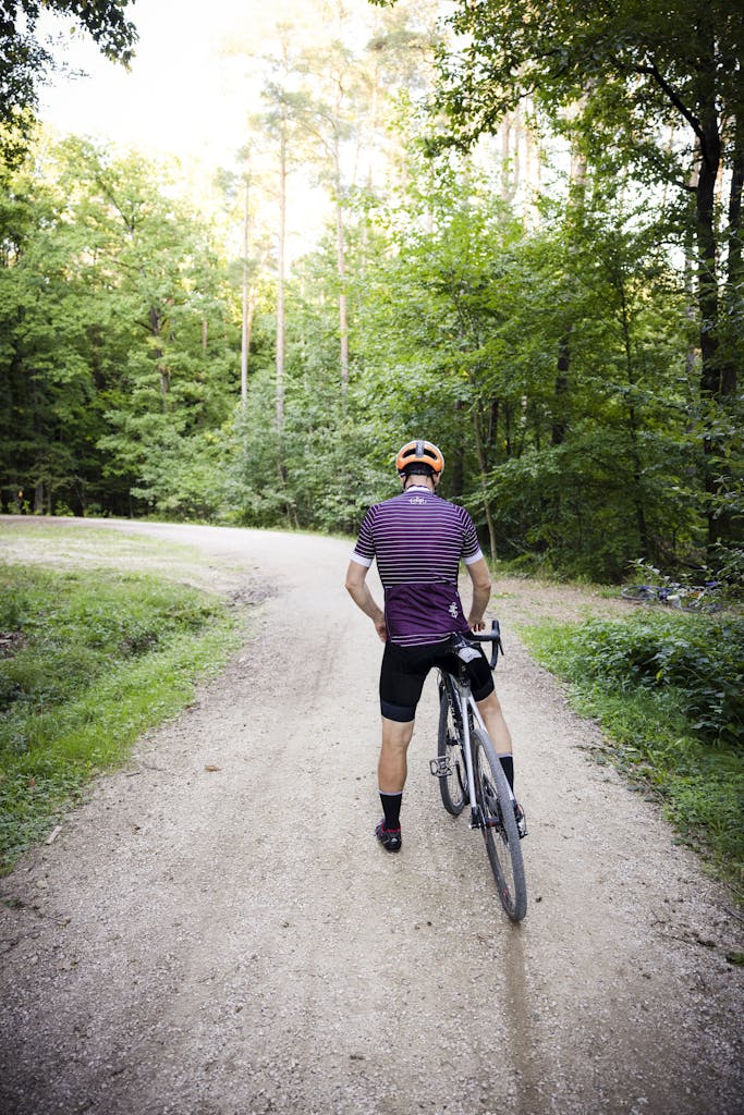 A cyclist pauses on a scenic forest trail during a summer ride.